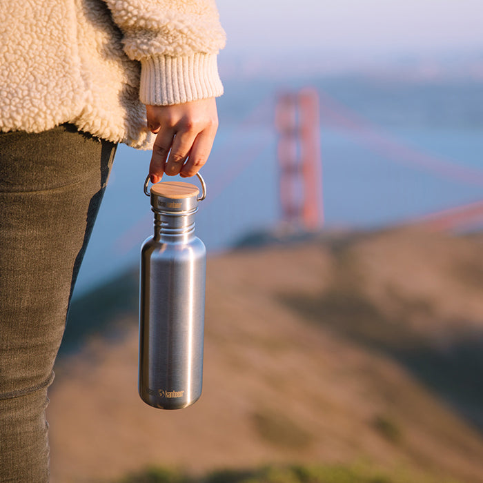 27oz-reflect-with-bamboo-cap-b5 K27SSLRF-BS-BAMBOO_reflect_bottle_bridge_lifestyle.jpg